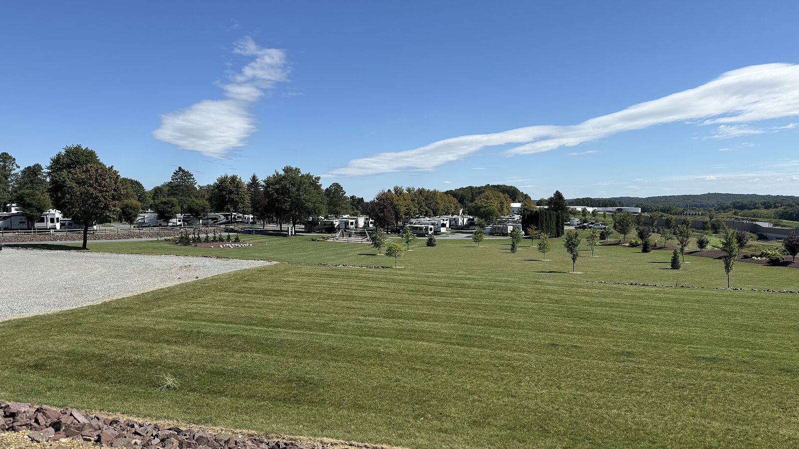 The wide mown field with campsites along the far side